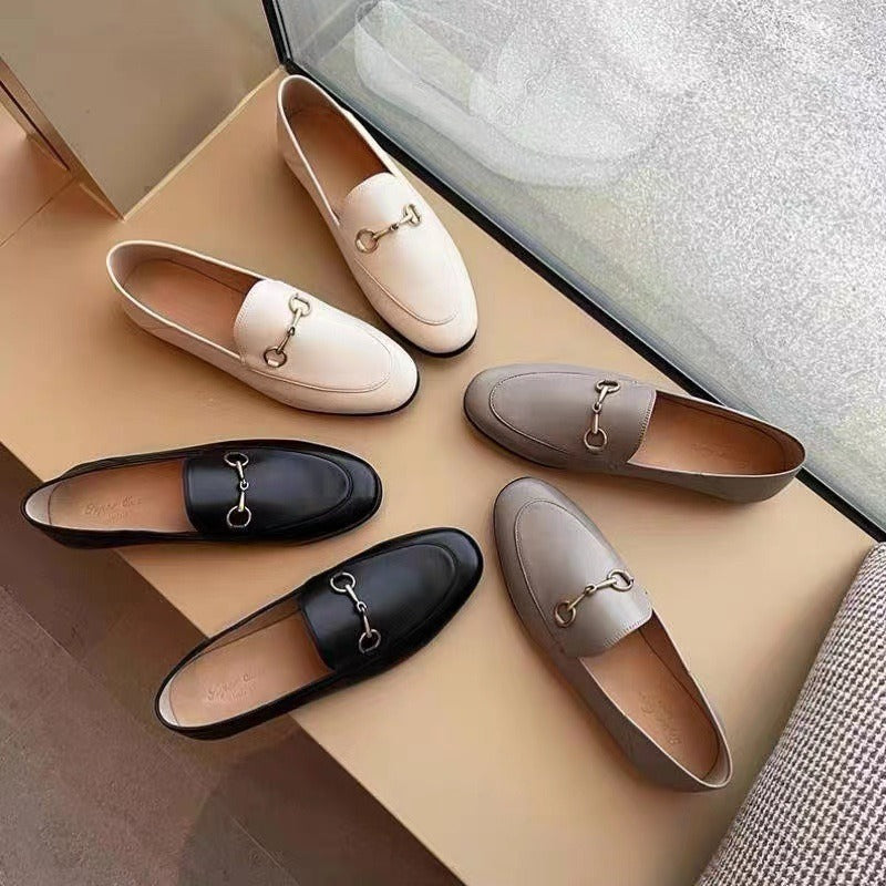 Women with horseshoe buckles and loafers wearing flat bottomed small leather shoes